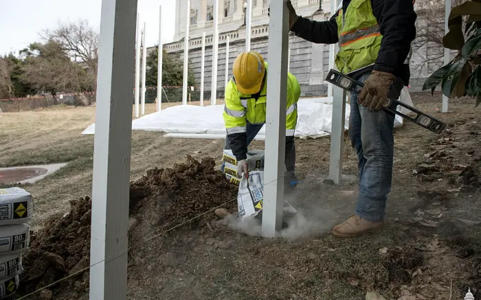 Crew member setting a steel fence post